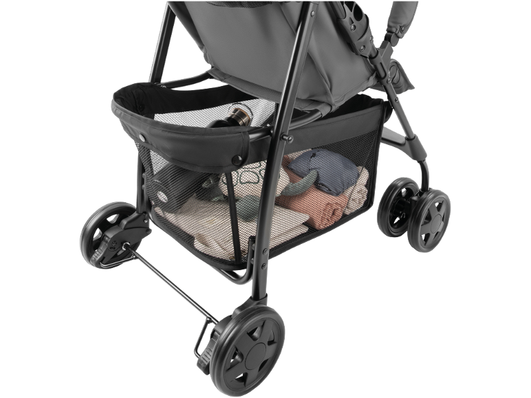 Close-up of a baby stroller's storage basket filled with a bottle, clothes, and a toy.