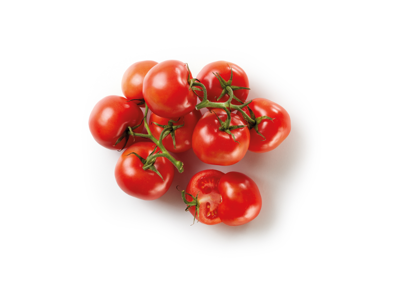 Fresh red tomatoes on the vine, one cut in half, on a white background