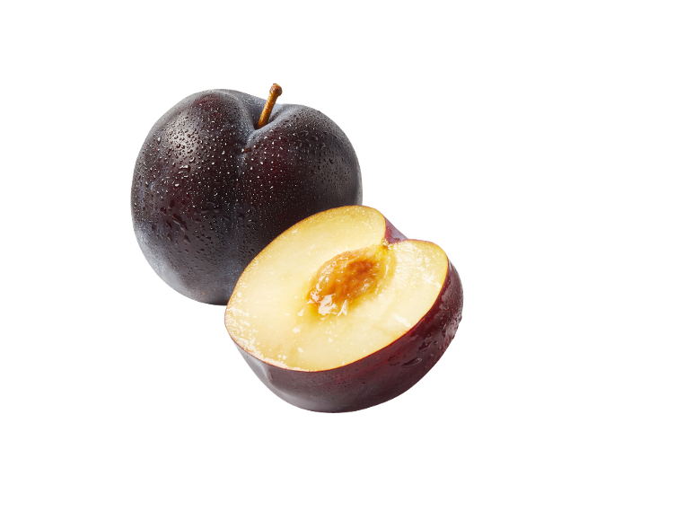 Ripe plum and half a plum with a pit on a black background.