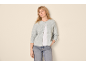 Woman in a grey knitted cardigan, white t-shirt, and blue jeans.