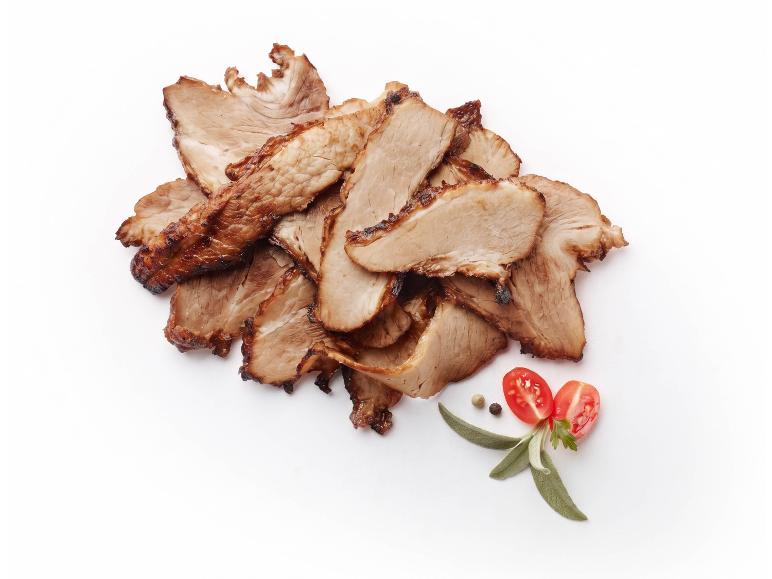 Slices of roasted meat with cherry tomatoes and herbs