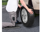 Man kneeling changing a car tire, using a kneeling pad.