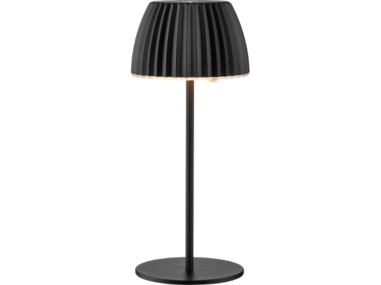 Black table lamp with a pleated shade and round base, illuminated.