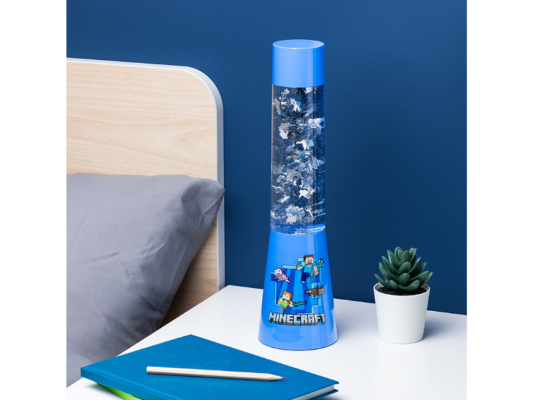 Blue decorative lamp with animated designs, next to a bed and a plant.