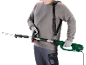 Man with shoulder strap holding an electric pole hedge trimmer.