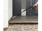 Man cleaning an entrance with a pressure washer.