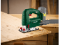 Green jigsaw with battery and suction hose, cutting wood.