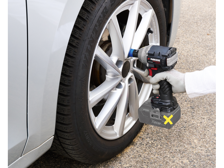 Person using a cordless impact wrench to change a car tire.