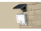 Solar-powered LED security light with motion sensor mounted on a brick wall.
