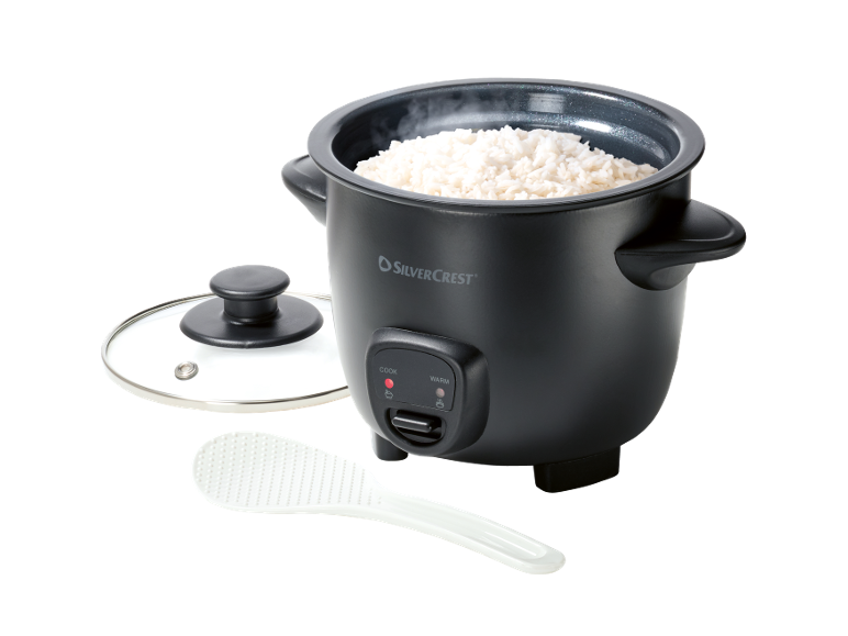 Black rice cooker with cooked rice, open lid, and white spoon.