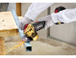 Worker cutting metal profile with a cordless angle grinder, sparks flying.
