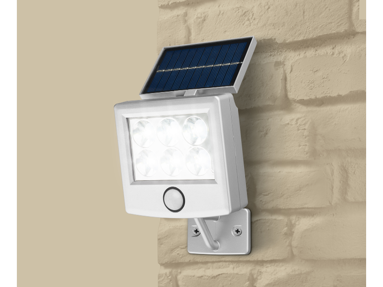 Solar LED spotlight mounted on a brick wall.