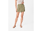 Woman in green shorts and flat sandals
