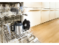 Open dishwasher with dishes, including a blender jug, in a modern kitchen.