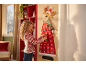 Girl with curly hair opening a pocket on a reindeer-shaped Christmas advent calendar.