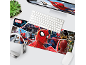 Desk setup with a comic-themed mouse pad featuring superheroes and villains, a keyboard, and headphones.