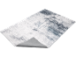 Abstract grey and white rug with a distressed pattern, showing the underside