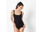 Smiling woman in black lace camisole and black briefs.