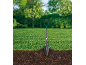 Garden spade stuck in the ground with grass and roots.