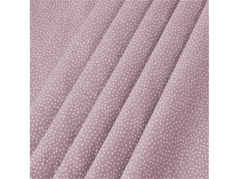 Lilac fabric with small white polka dots and folds.