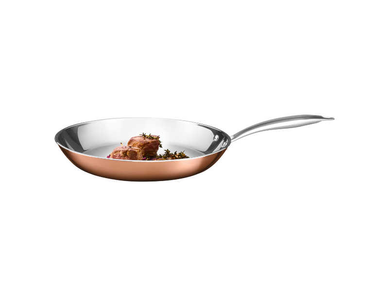Copper frying pan with meat and herbs