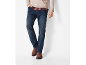 Man in blue jeans, beige sweater and plaid shirt, brown boots.