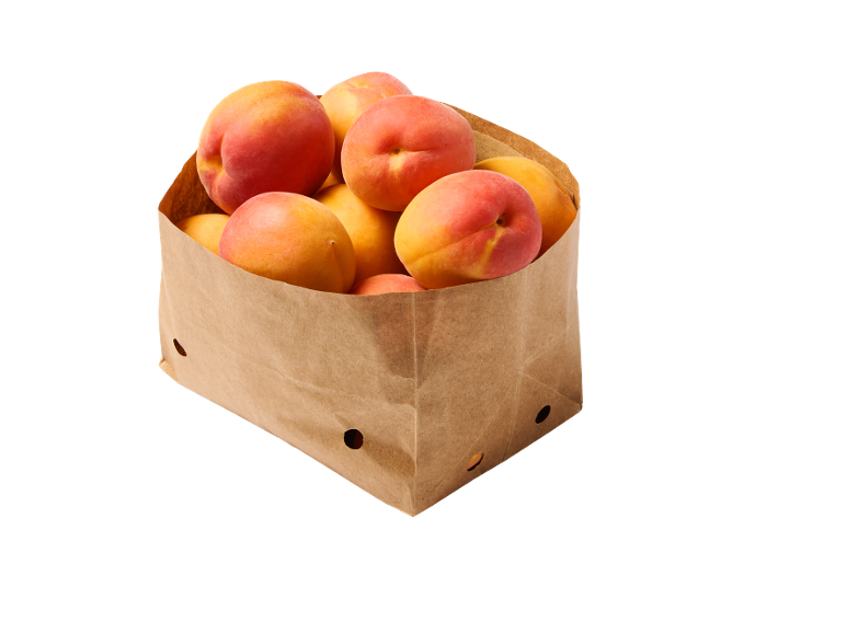 Fresh apricots in a brown paper bag.
