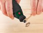 Man changing the accessory of a hand rotary tool with a wrench