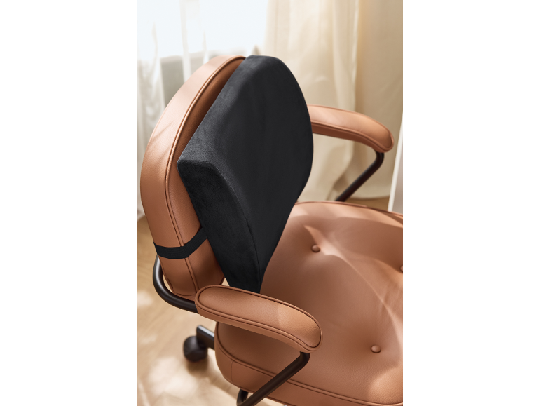 Black lumbar cushion on a brown leather office chair