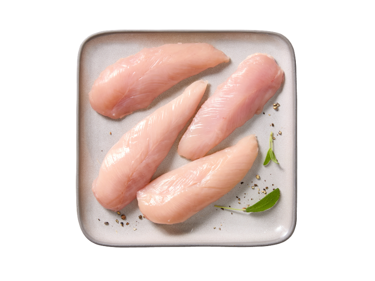 Raw chicken fillets on a plate, seasoned with pepper and sage.