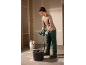 Woman mixing mortar with an electric mixer on a construction site.