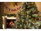 Snowy Christmas tree with decorations and a lit fireplace, garland, and Advent calendar.