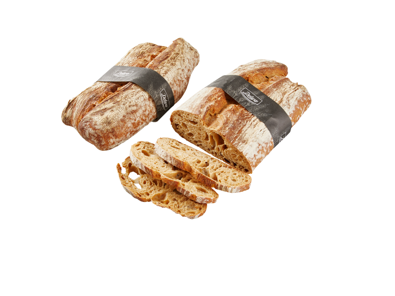 Two loaves of bread, one sliced, with a black band featuring the text 'Deluxe'.