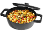 A black pot filled with gnocchi, zucchini, mushrooms, and tomatoes, with a lid resting on top.