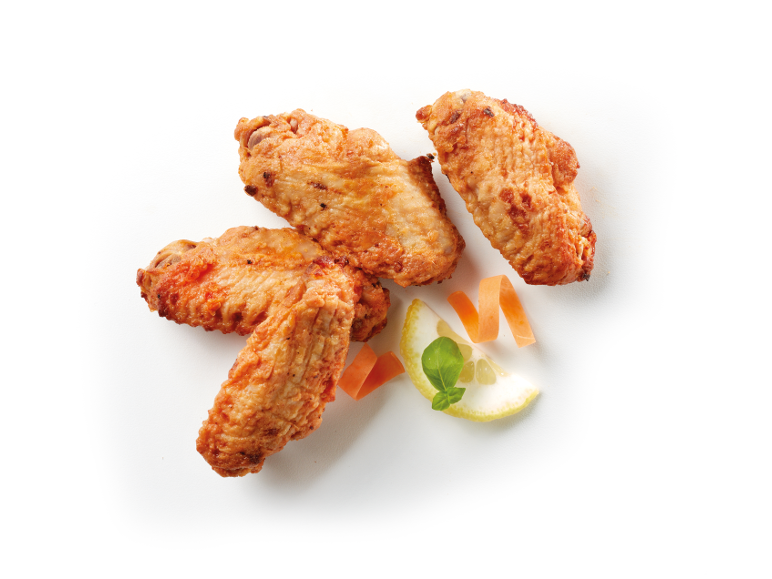 Fried chicken wings with lemon, mint, and carrot strips.