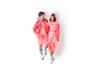 Smiling couple in transparent red rain ponchos and colorful accessories.