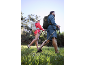 Couple with hiking backpacks and poles enjoying a Nordic walk in nature.