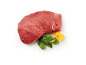Raw beef steak with spinach leaves and yellow cherry tomatoes.