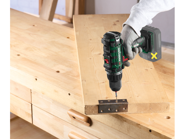 Cordless drill fixing a hinge to a wooden board.