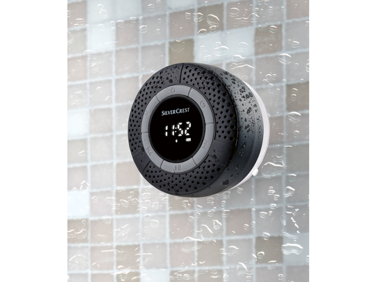 Waterproof bathroom speaker with time display, mounted on tiles with water droplets.