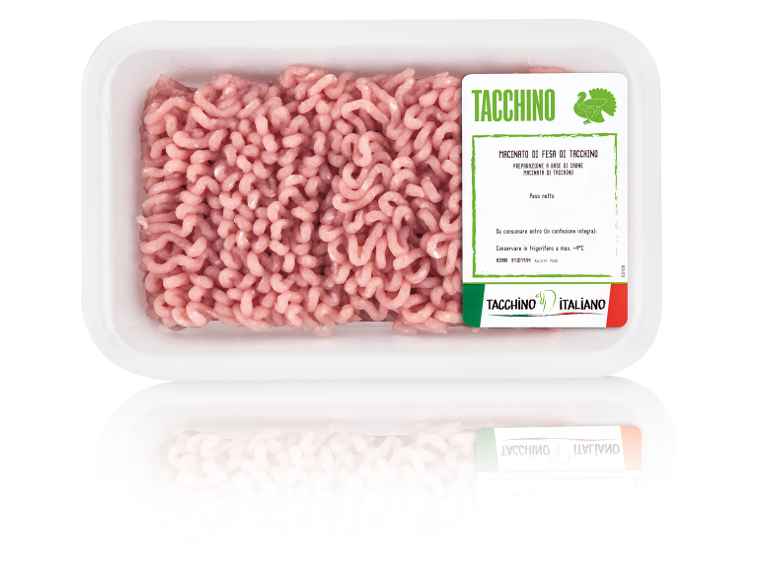 Tray of ground turkey meat with a green label, featuring text in Italian.