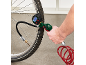 Man inflating a bicycle tire with a digital tire pressure gauge and a red hose.