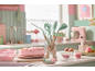 Kitchen utensils and a pink cake in a pastel-themed kitchen.