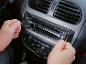 Man installing a car radio into a car dashboard.