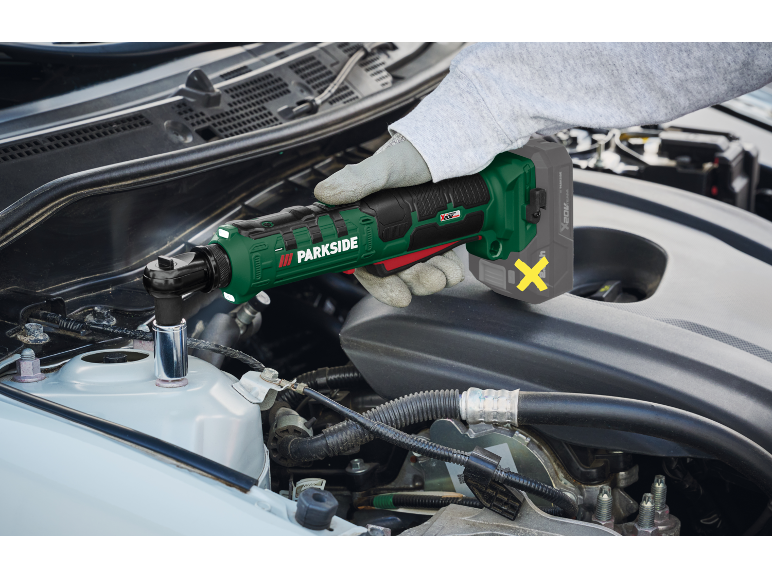 Cordless ratchet wrench in use for car repair.