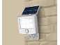 Solar LED spotlight mounted on a brick wall.