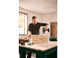 Man drilling into a wooden crate with a cordless drill on a workbench.