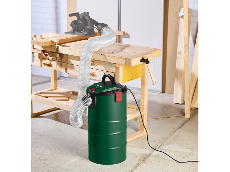 Ash and sawdust vacuum cleaner with a flexible hose and a saw on a workbench.