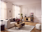 Living room with a beige sofa, wooden coffee table and cabinet, light rug, and curtains.