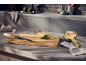 Cut artichokes and garlic on a kitchen counter with a knife and cutting board.